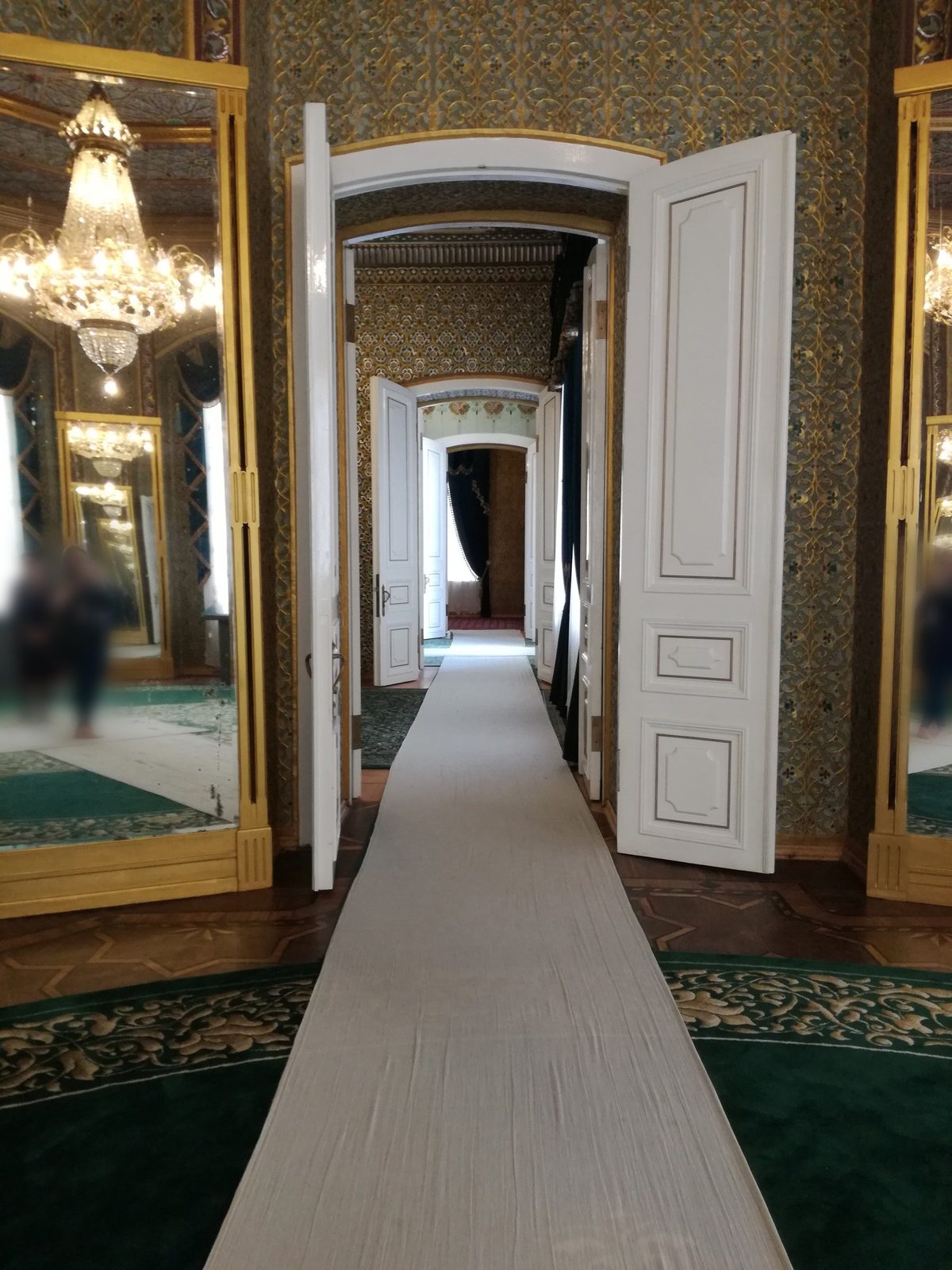 Mirrors, chandeliers and white doors in the Nurullaboy Palace