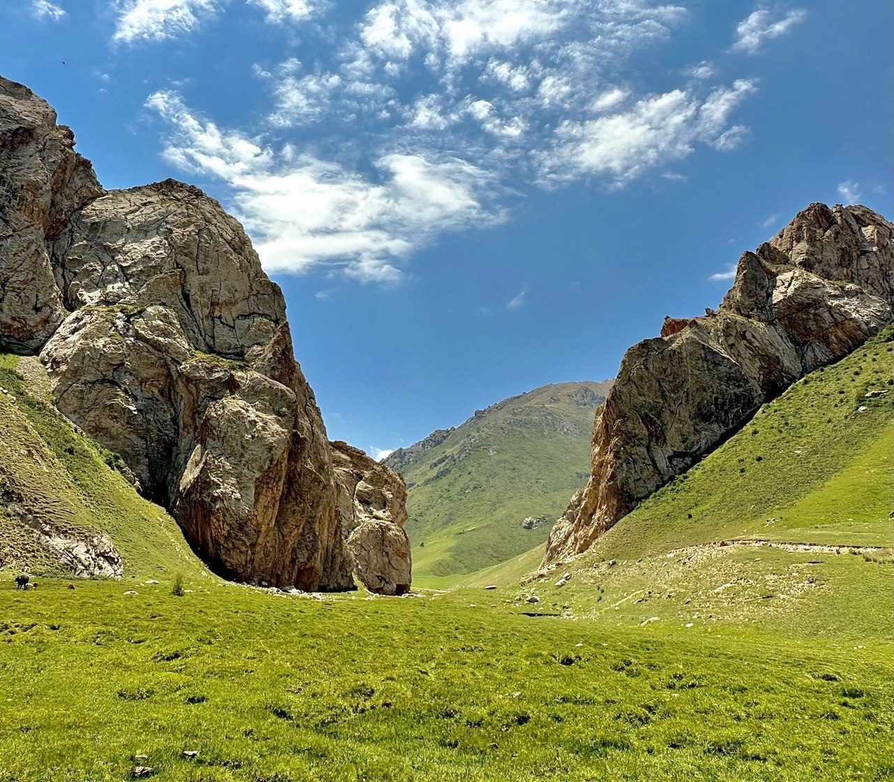 A rocky gorge opening onto a summer pasture in Kyrgyzstan