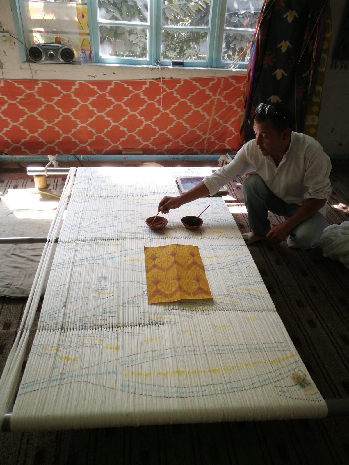 Marking the ikat pattern on the stretched warp before dyeing