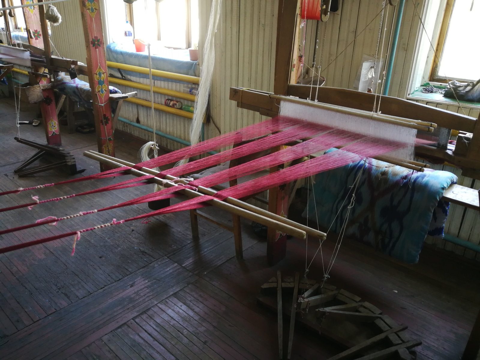 A hand loom with a dyed warp in the weaving room