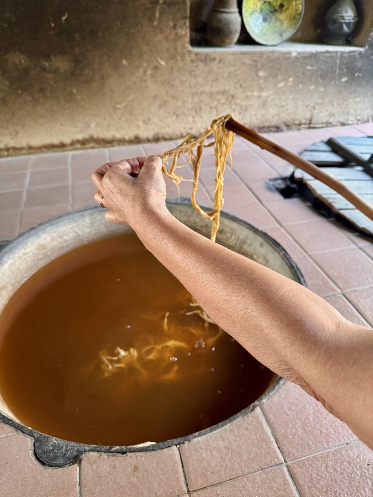 Kokt mullbärsbast som lyfts upp ur kitteln